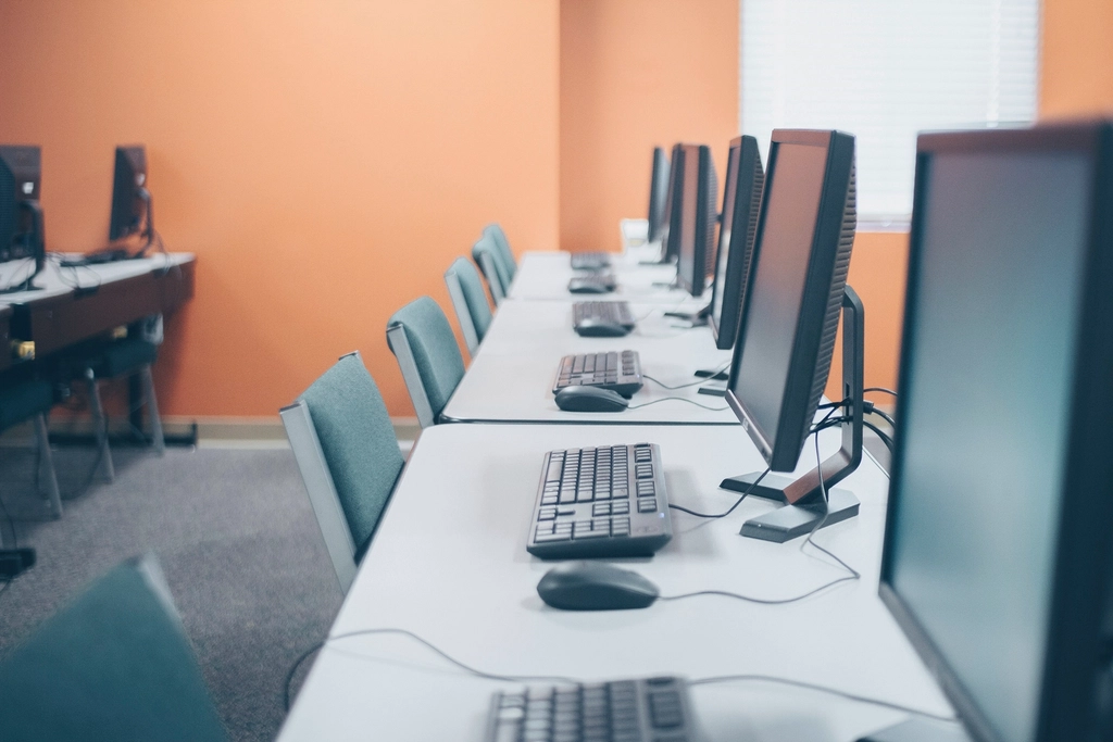 Reviewing a stack of software and app subscriptions on desktop computers