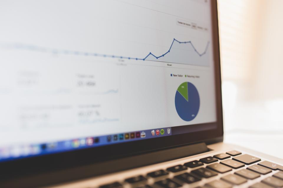 Laptop screen showing an analytics line chart and pie graph, illustrating how to interpret demand forecasting accuracy for a Shopify store
