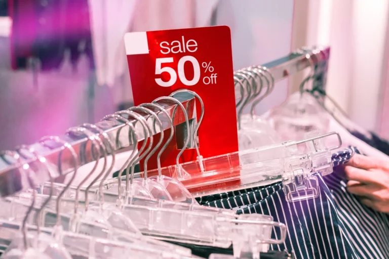 A 50% off sale sign on a clothing rack, illustrating retail discount pricing