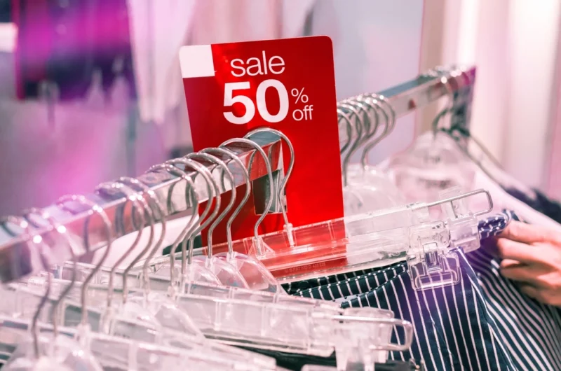 A 50% off sale sign on a clothing rack, illustrating retail discount pricing