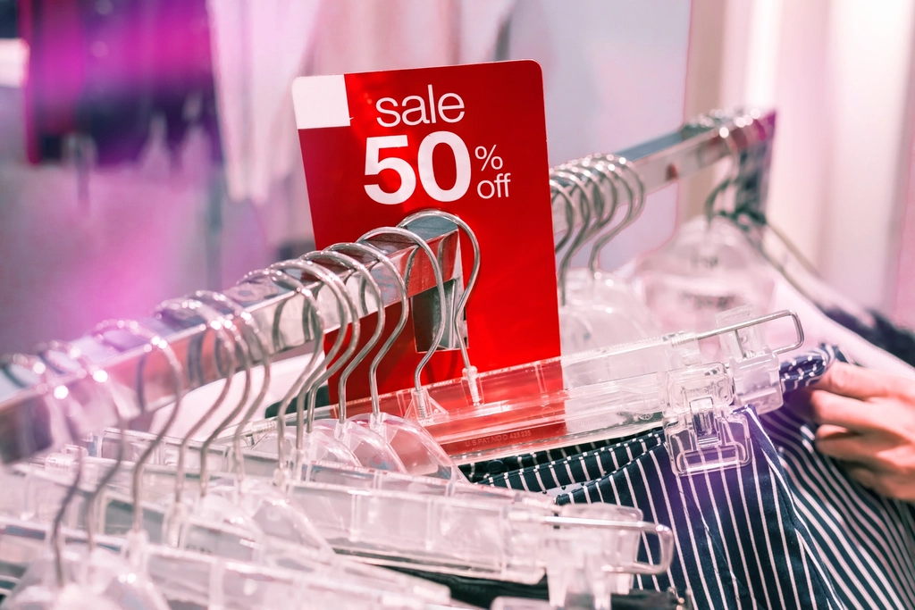 A 50% off sale sign on a clothing rack, illustrating retail discount pricing