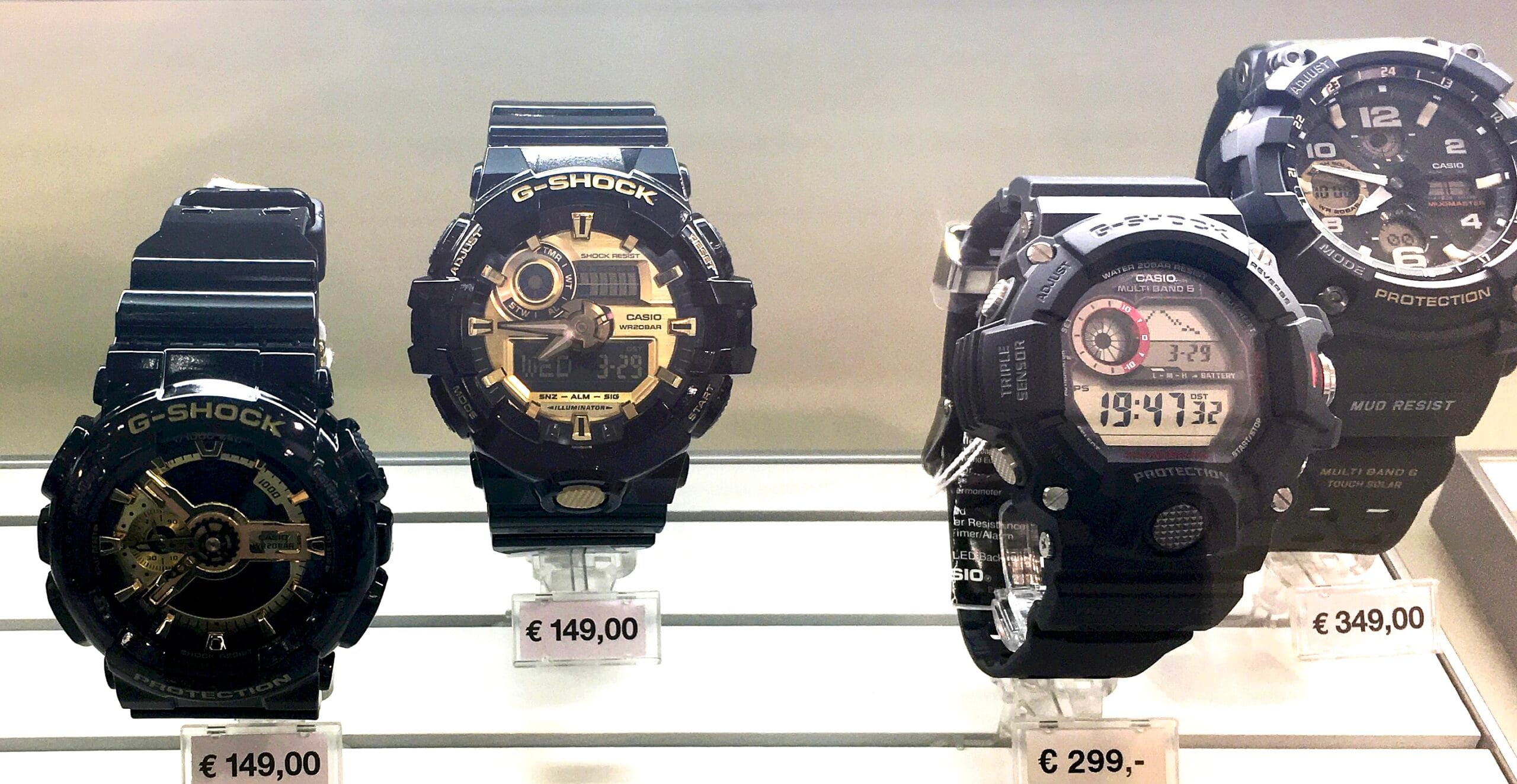 Casio G-Shock watches displayed in a retail shop case with visible price tags
